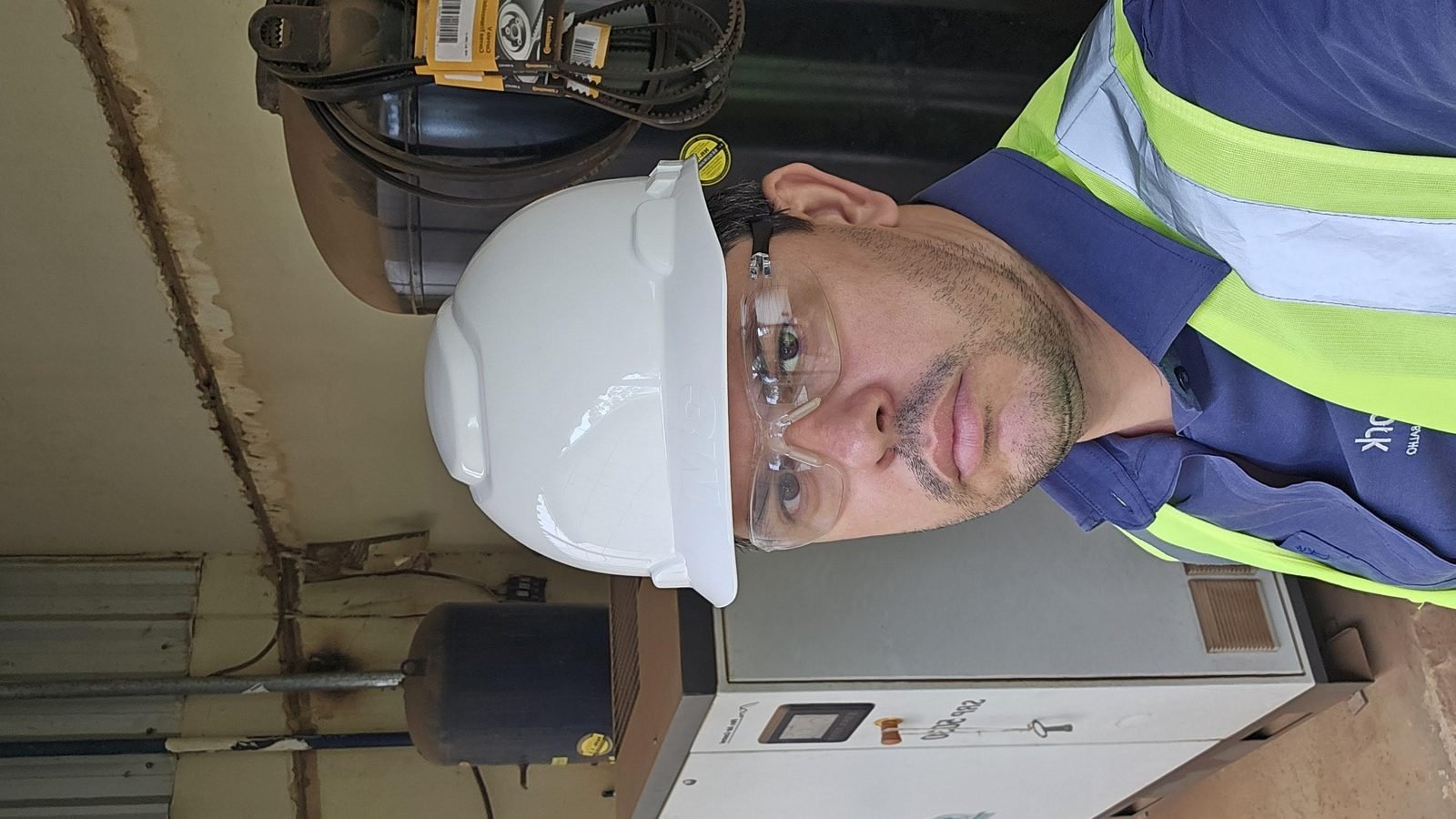 Engenheiro da Sework Engenharia com EPI durante inspeção de compressor de ar e vaso de pressão