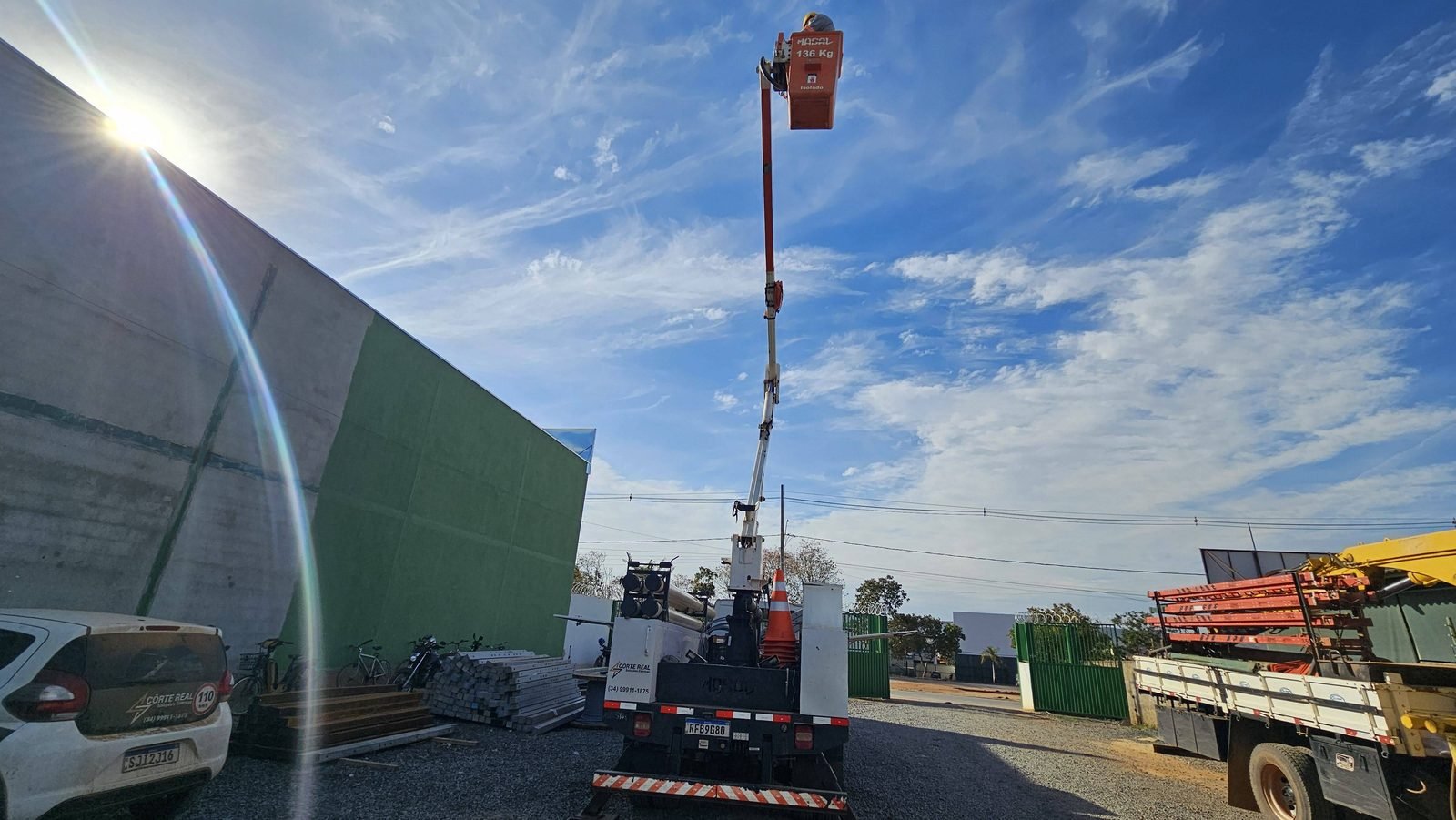 Cesto aéreo veicular elevado em altura máxima com operador utilizando cinto tipo paraquedista durante ensaio funcional