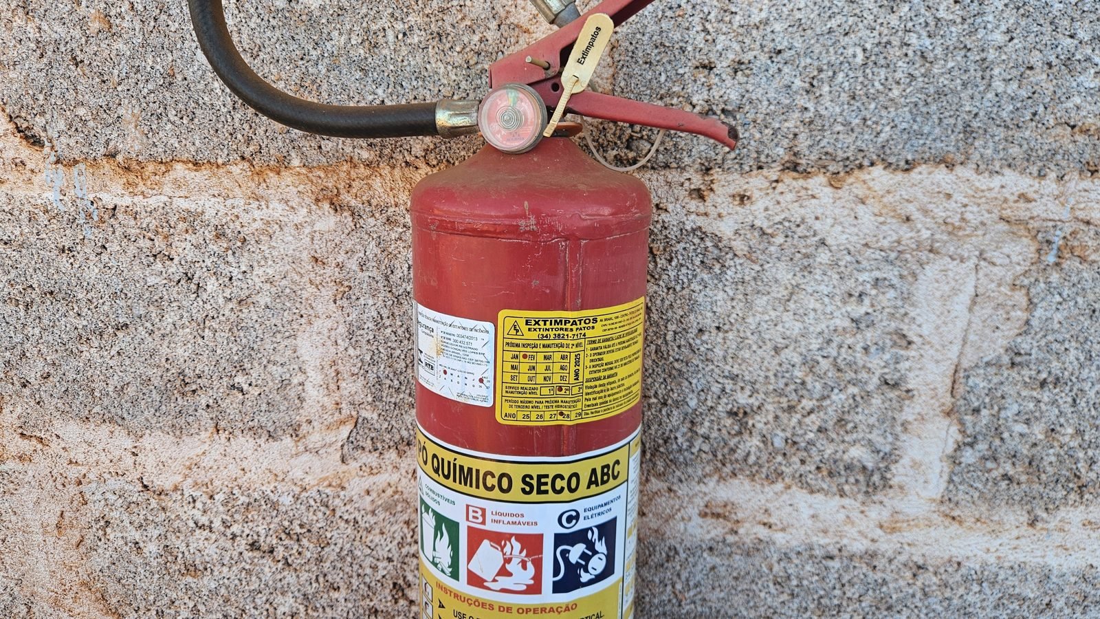 Extintor de pó químico ABC com etiqueta de manutenção e manômetro em faixa verde