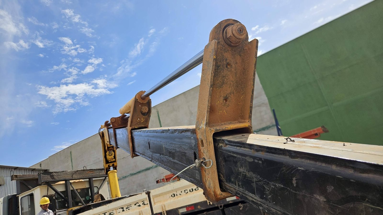 Articulação e pino da lança de guindaste articulado inspecionados quanto a trincas, folgas e desgaste
