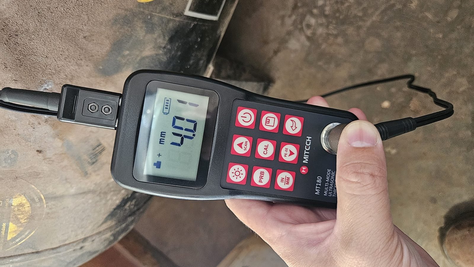 Medidor de espessura por ultrassom indicando 4,01 mm durante inspeção NR-13 de reservatório de ar comprimido
