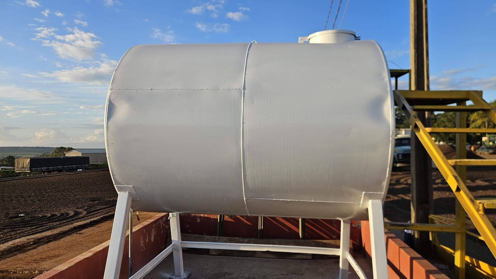 Tanque de diesel aéreo sobre berço metálico com escada e guarda-corpo de acesso